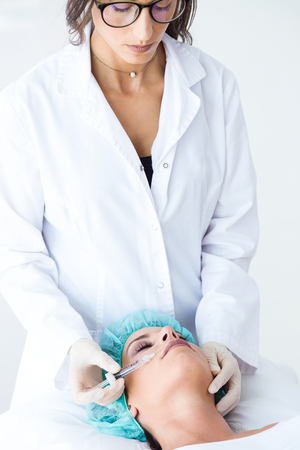 Portrait of beautiful young woman getting botox cosmetic injection in her face.の写真素材