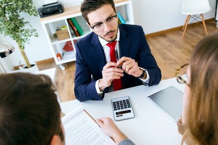 Portrait of business young man explaining terms of contract to his clients in the office.