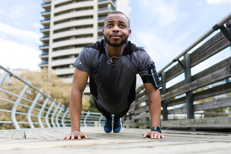 Portrait of fit and sporty young man doing stretching in the city.の写真素材