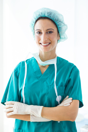 Portrait of confident female medical worker wearing hat and mask looking to the camera.の写真素材