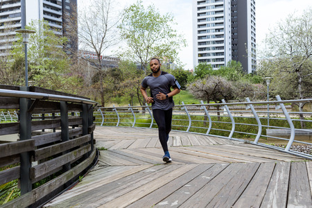 Portrait of fit and sporty young man running in the city.