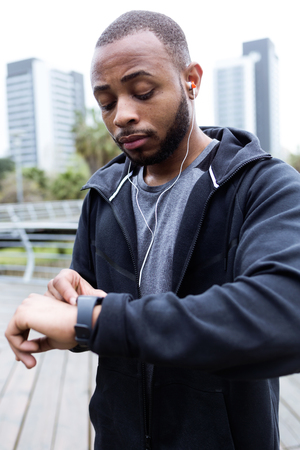 Portrait of fit and sporty young man preparing for a run in the city.の写真素材