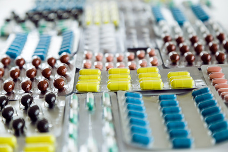 Portrait of assorted pharmaceutical medicine pills, tablets and capsules on the table.
