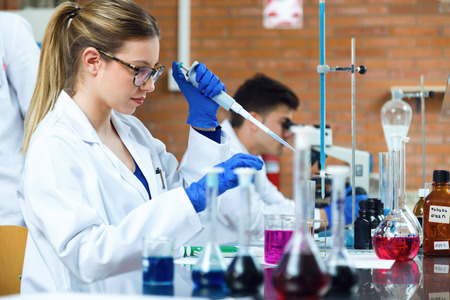 Portrait of young scientists carrying out an experiment in a laboratory.