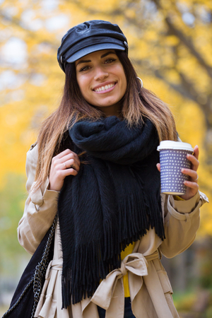 Shot of pretty young woman looking at camera while walking through the park in autumn.の写真素材