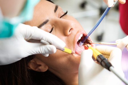 Close-up of beautiful young female patient receiving dental care in dental clinic.の写真素材