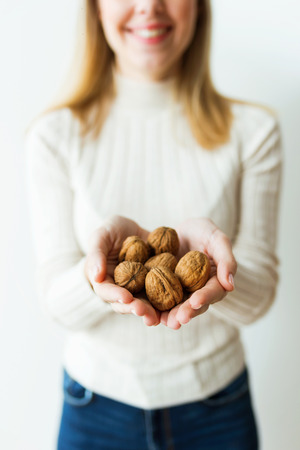 Charming young woman hands holding almonds nuts on isolated white background.の写真素材
