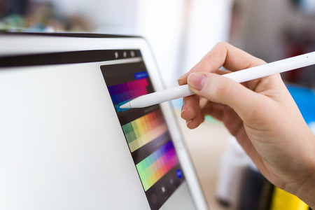 Close-up of young designer woman hand working with her digital tablet at the office.の写真素材