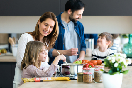 Shot of beautiful cute family having fun while cooking together in the kitchen at home.の写真素材