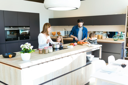 Shot of beautiful cute family having fun while cooking together in the kitchen at home.の写真素材