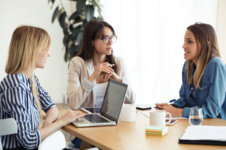 Shot of three business colleagues working together in modern workspace. Brainstorming concept.の写真素材