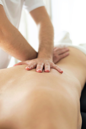 Shot of young physiotherapist doing a back treatment to the patient in a physiotherapy room. Rehabilitation, medical massage and manual therapy concept.の写真素材