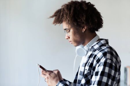 Shot of handsome young african american man using his mobile phone over white background.