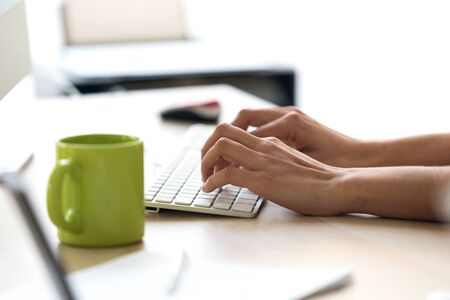 Close-up of the hands of a woman using the computer in the office.