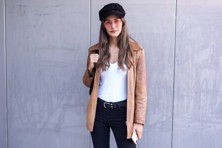 Portrait of pretty young woman looking at camera while standing in the street.