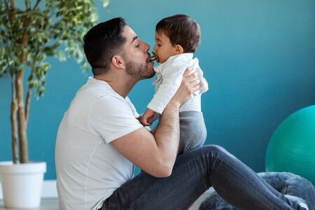 Shot of handsome young father with his baby playing together and having fun at home.の写真素材