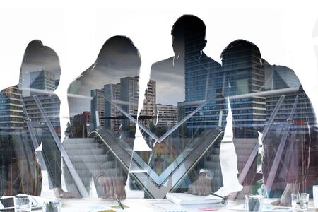 Double exposure of silhouette of business team talking in the meeting on coworking space over city life background.の写真素材