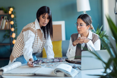 Shot of two beautiful designer women working in a design project while choosing materials in the office.の写真素材