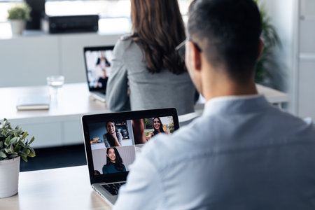 Back view of handsome mature businessman making video call with diverse colleagues on online...