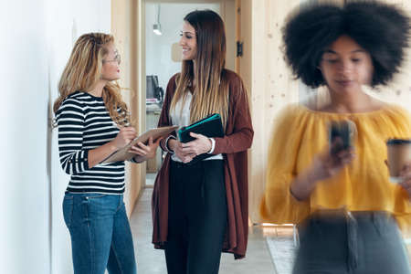 Shot of three smart multiethnic businesswomen working while walking across the hall of coworking place.の写真素材
