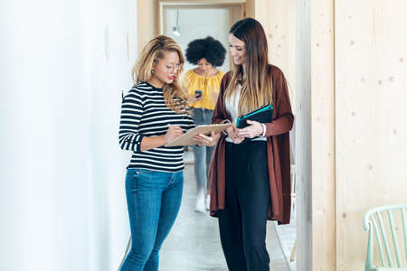 Shot of three smart multiethnic businesswomen working while walking across the hall of coworking place.の写真素材