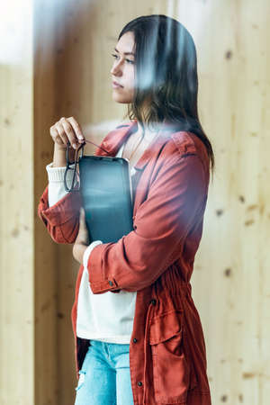 Shot of pretty businesswoman working with digital tablet while standing near the window in coworking...