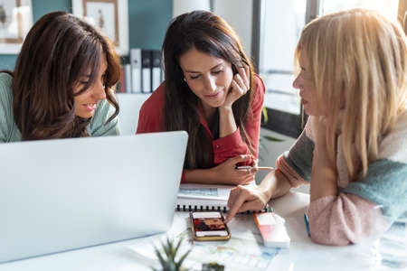 Shot of group of multiage designer women working in a design project while choosing materials in the office.の写真素材