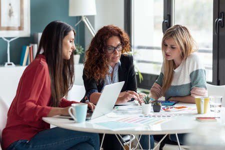 Shot of group of multiage designer women working in a design project while choosing materials in the office.の写真素材