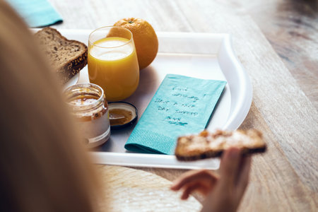 Shot of close-up of beautiful woman hands having healthy breakfast in the living room at home.の写真素材