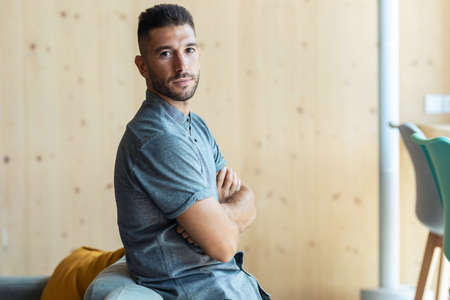 Portrait of confident man looking at camera while in a coworking place.の写真素材