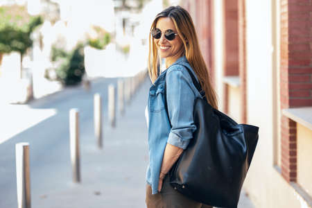 Shot of beautiful mature business woman looking at camera while walking down the street.の写真素材