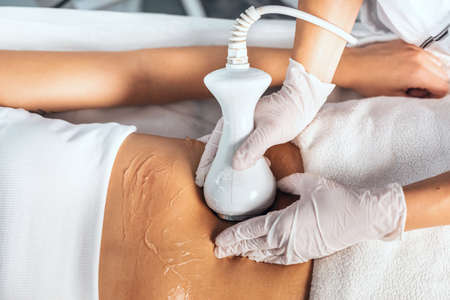Shot of cosmetologist makes the procedure an ultrasonic cleaning of skin of a beautiful young woman on the spa center.の写真素材
