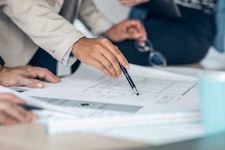Close up of businessteam hands on meeting discussing graphics in a coworking place.