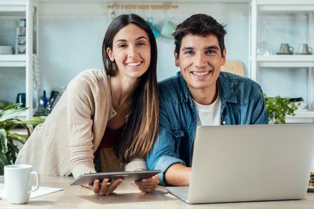 Shot of lovely young couple cooking together in the kitchen at home.の写真素材