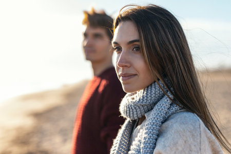 Shot of beautiful young couple in love enjoying the day in a cold winter on the beach.の写真素材