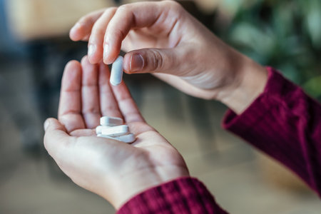 Close up young woman with depression and anxiety taking pills at homeの写真素材