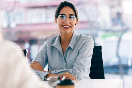 Shot of beautiful elegant businesswoman looking at camera while sitting in the office