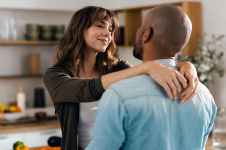 Shot of cute lovely couple hugging while having a good time in the kitchen at homeの写真素材