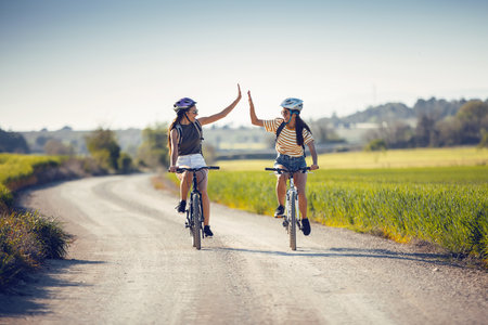 Shot of young women friends cycling while clapping their handsの写真素材
