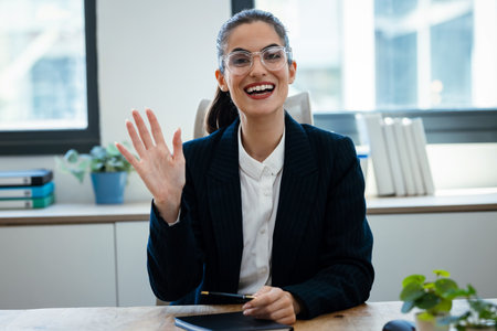 Shot of confident business woman speaking through the webcam while making a video conference from the officeの写真素材