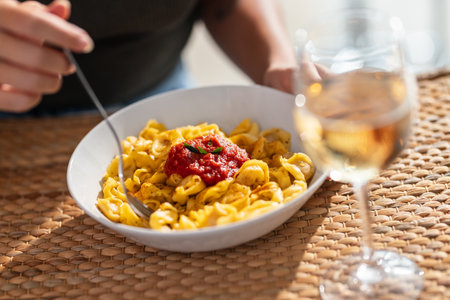 Close up of young woman hands eating a plate of pasta