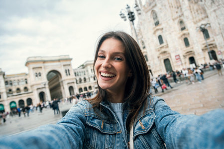 Shot of beautiful taking pictures of herself with her smartphone while sightseeing on the streets of...