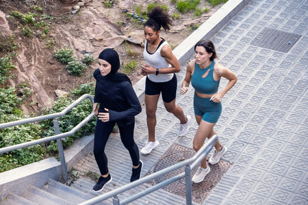 Shot of a group of three sportswomen running together through the cityの写真素材