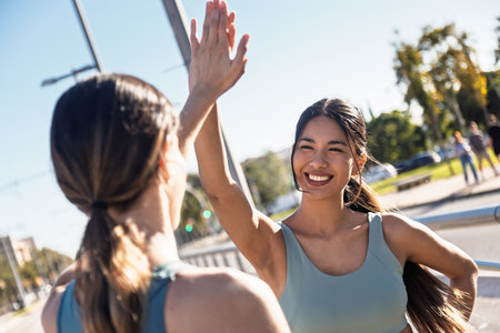 Shot of two sporty friends celebrating after going for a run around the cityの写真素材