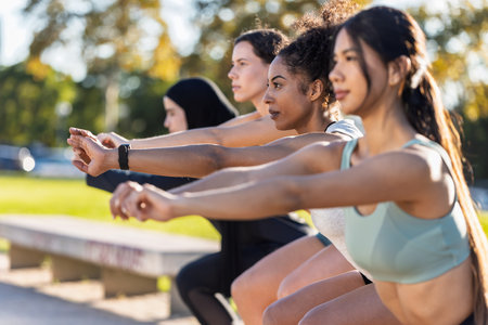 Shot of a group of sporty friends women doing stretching after running in the parkの写真素材