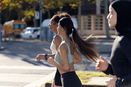 Shot of a group of three sportswomen running together through the cityの写真素材