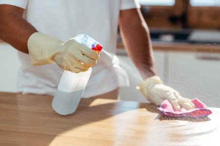Close up of hands man cleaning kitchen at homeの写真素材