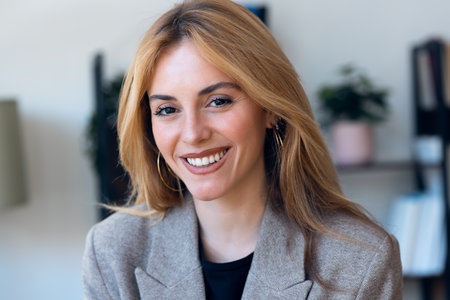 Portrait of smiling lawyer woman working while looking at camera in her modern office