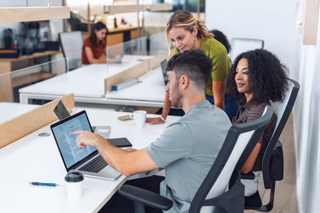 Shot of business people working with laptop and talking about their new project together in a coworking placeの写真素材