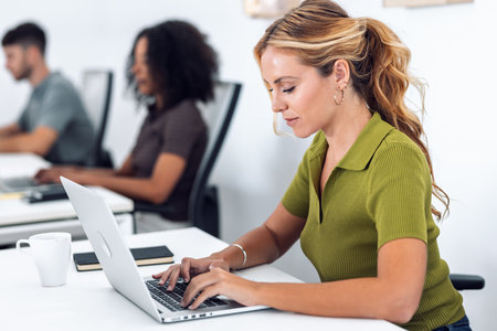Shot of business people working with laptops in a coworking place